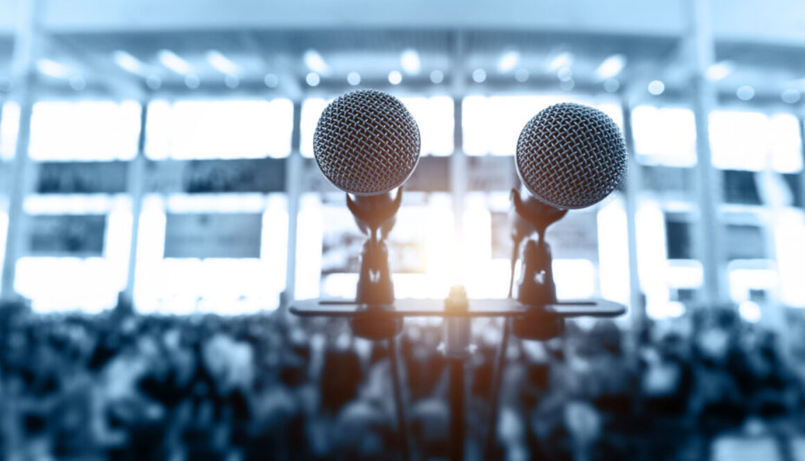 Closeup microphone in auditorium with blurred people in the background